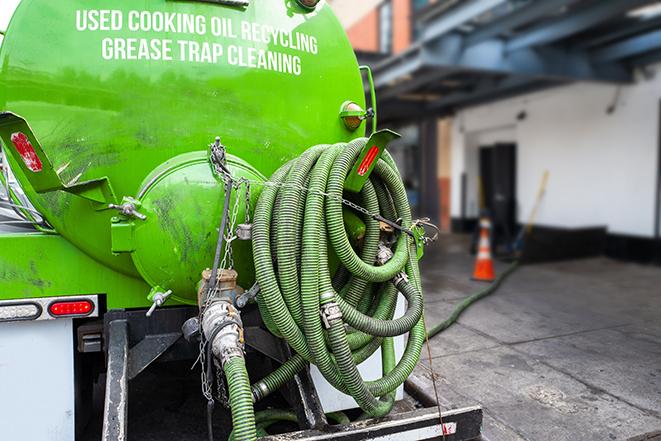 a grease trap being pumped by a sanitation technician in Gilbert, AZ